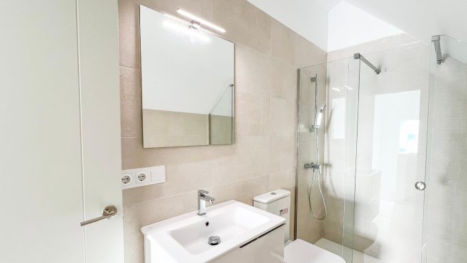 BATHROOR - Baño 1 Baño moderno con ducha, espejo y lavabo. Paredes de tonalidades claras.