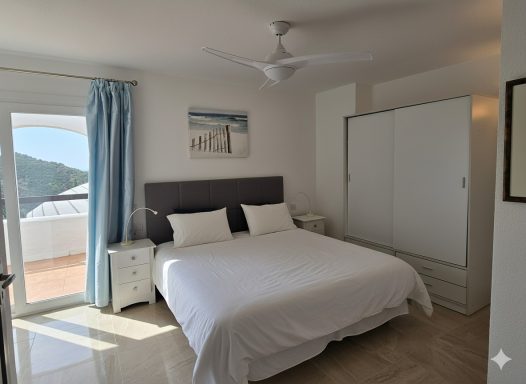 Habitación luminosa con cama doble, armario y ventana con vista al exterior.